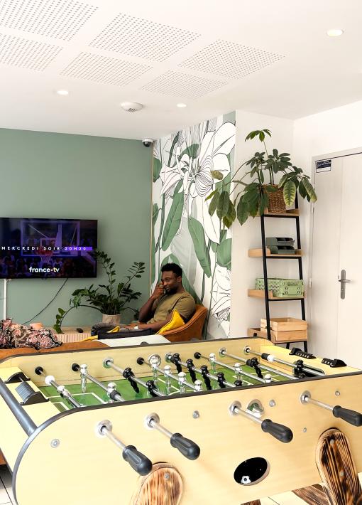 Salon accueillant avec une table de baby-foot et une télévision