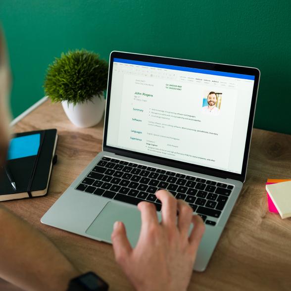 jeune homme travaillant sur son ordinateur pour faire son CV