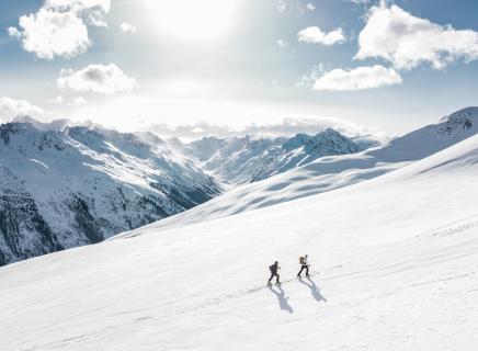 deux personnes marchant dans la neige en montagne